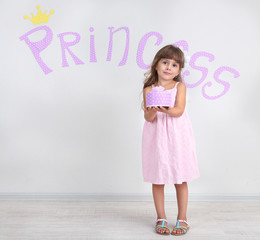 Little girl posing on grey wall background