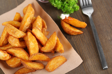 Home potatoes on tracing paper on wooden table