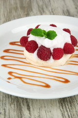 Tasty meringue cake with berries on wooden table