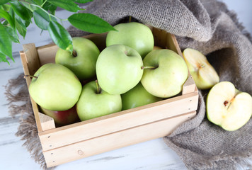 Juicy apples in box on wooden table
