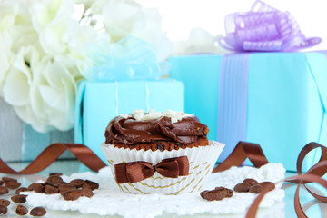 Tasty cupcake with gifts close up