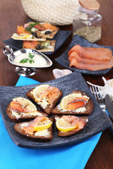 Salmon sandwiches on plate  on wooden table close-up