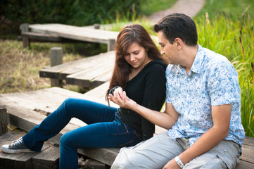 Couple in love sitting on the bridge in autumn park