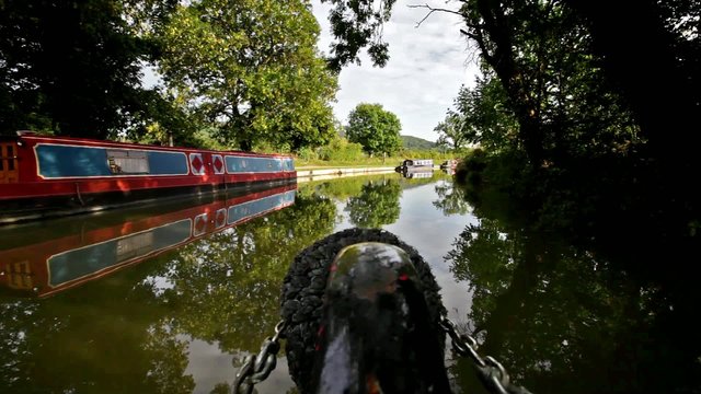 View from a narrow boat as it travels along a rural canal