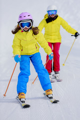 Fototapeta na wymiar Skiing, skiers on ski run - child skiing, ski lesson
