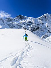Fototapeta na wymiar Freeride - Man with skis climbs to the top
