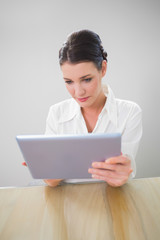 Focused businesswoman working on tablet pc