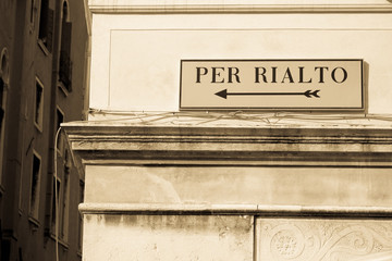 Directional sign to Rialto bridge on old Venetian building