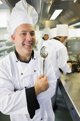 Senior chef posing proudly in a kitchen