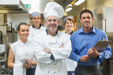 Chef-kok poseert met het team achter hem