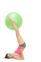 Fototapeta na wymiar Smiling sporty brunette holding exercise ball between legs
