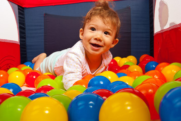 Fototapeta na wymiar Baby lying in colorful balls