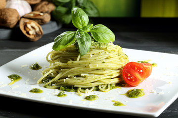 pasta vegetariana spaghetti con pesto sfondo grigio
