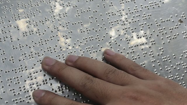 Asian boy hand read braille