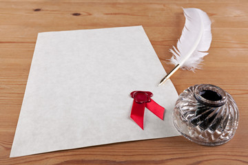 Blank parchment paper with red wax seal quill and ink well