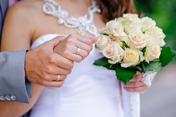 Obraz na płótnie Canvas Hands and rings and wedding bouquet