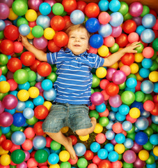 Fototapeta na wymiar Happy child playing with colorful plastic balls