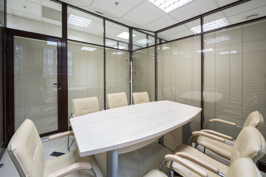 Light Office Blinds Closed With A Table And Leather Chairs