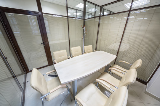 Small meeting room blinds closed with a table and leather chairs