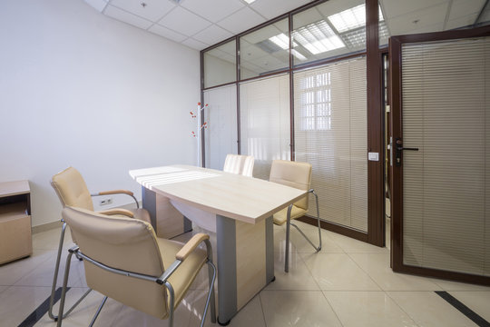 Meeting room blinds closed with a table and  chairs