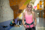 smiling girl with climbing equipment on climbing gym