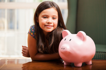 Happy little girl saving some money