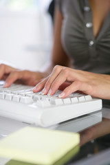 Woman typing on computer keyboard