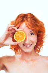 Funny girl with red hair holding slice of orange