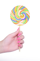 Hand holding giant colorful lollipop isolated on white