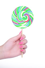 Hand holding giant colorful lollipop isolated on white