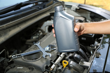 Obraz premium Auto mechanic hand holding motor oil