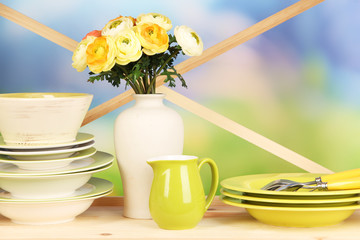 Beautiful dishes on wooden cabinet on natural background