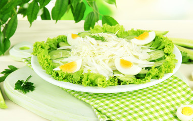 Delicious salad with eggs, cabbage and cucumbers on wooden