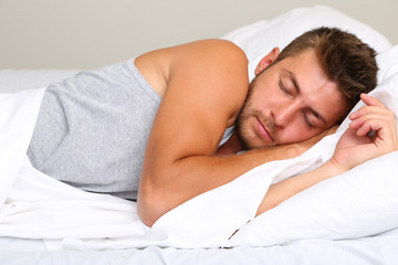 Handsome young man in bed