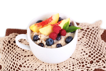 Oatmeal in cup with berries on napkins isolated on white