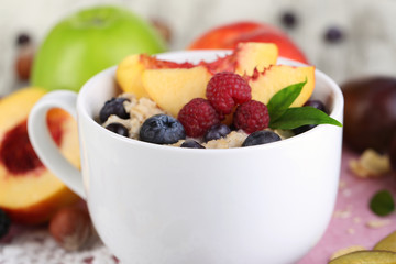 Oatmeal in cup with berries on napkins on wooden table