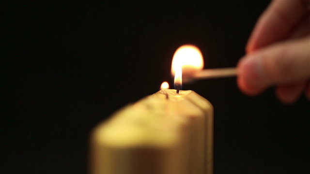 Hand lighting four advent candles