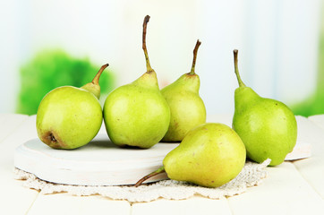 Fototapeta na wymiar Pears on wooden cutting board, on light background