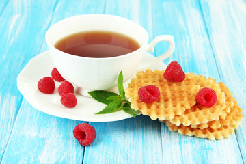 Cup of tea with cookies and raspberries on table close-up