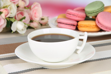 Coffee and macaroons on table on light background