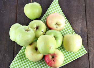 Juicy apples on napkin on wooden table