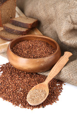 Buckwheat groats in bowl and wooden spoon closeup