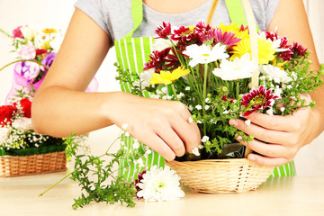 Obraz na płótnie Canvas Florist makes flowers bouquet in wicker basket