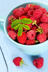 fresh raspberrie in a blue cup