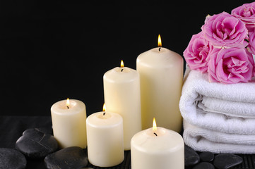 spa composition of towel, candles and roses