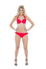 Cheerful smiling blonde model posing with hands on hips wearing