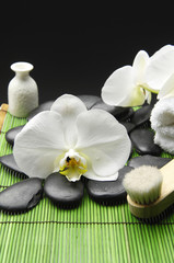 white orchid with pebble stone and towel on green mat