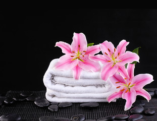 Obraz na płótnie Canvas Pink lily and towel.zen stones on mat