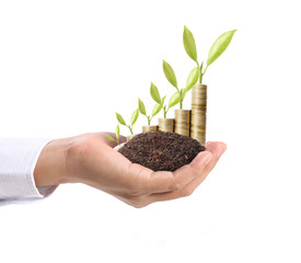 Businessman holding plant sprouting from handful of coins
