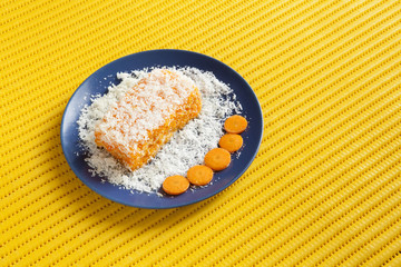 Carrot and coconut cake with yellow background